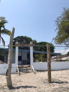 un edificio sulla spiaggia con due tronchi nella sabbia di Casa Greca a Playa Blanca