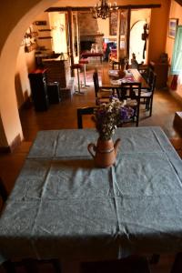 una mesa con un jarrón de flores encima en Hosteria la granja en Huacalera