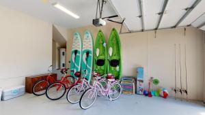 a group of bikes parked in a room with surfboards at Luxury Rental Walkable To Beach With Wide Water Views I Pet Friendly in Henry Key