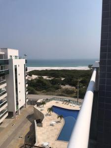 vistas a la piscina y al océano desde un edificio en Lebon Vivant cobertura vista mar en Arraial do Cabo