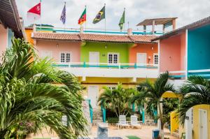 a colorful building with palm trees in front of it at Pousada Angelica in Jericoacoara