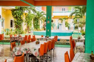 um restaurante com mesas e cadeiras e uma piscina em Pousada Angelica em Jericoacoara