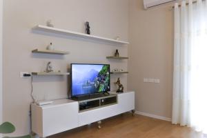 a living room with a television on a white entertainment center at Olimpia Inn in Berat
