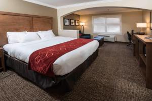 una camera d'albergo con un letto grande e una scrivania di Comfort Suites Fresno River Park a Fresno