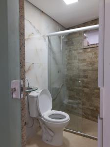 a bathroom with a toilet and a glass shower at Condomínio Sítio Bom - Mangaratiba - Costa Verde in Mangaratiba
