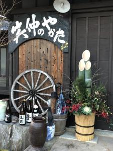 a wooden door with a wooden wheel and some bottles at Shotyu No Yakata / Vacation STAY 49506 in Saga