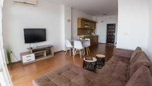 sala de estar con sofá y TV de pantalla plana en White Coast Beach Apartments, en Kavarna