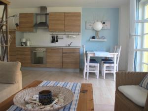 a living room with a kitchen and a table with a bowl at Wiesenstraße 55 Whg 1 - Meeresbrise in Zingst