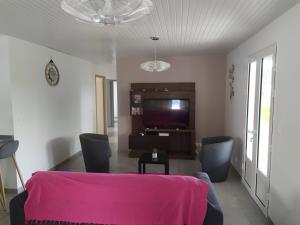 sala de estar con mesa y sillas rosas en VILLA GLYCIRIDIA en Le Vauclin