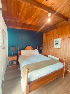 1 dormitorio con 1 cama con techo de madera en Glenaire Cottages, en Glenaire