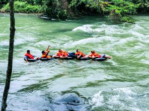 a group of people in a raft in a river at Hostal Oasis The Traveler in Lanquín