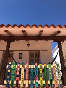a colorful wooden fence in front of a house at El Pueblito Hotel Boutique in Samaipata