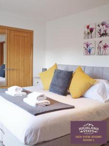 uma cama com almofadas amarelas e azuis em Highland Stays - Ben View Double Rooms em Fort William