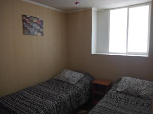 a small room with a bed and a window at Departamento Amoblado a Pasos del Faro in La Serena