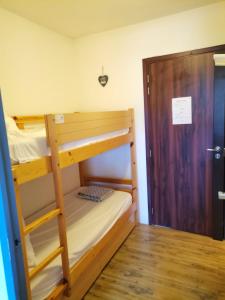 Cette chambre comprend 2 lits superposés et une porte en bois. dans l'établissement tecy Pierre et vacances, à Sainte-Maxime