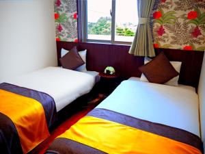 Un pat sau paturi într-o cameră la Terrace Garden Okinawa