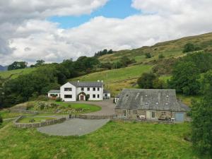 a house in the middle of a green hill at Ghyll Bank Byre in Staveley