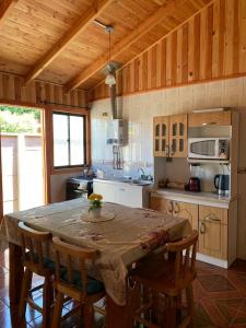 a kitchen with a table and chairs in a kitchen at Cabañas gonzalez caniupan in Licán Ray