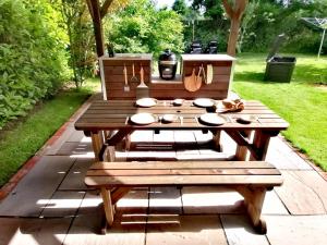 drewniany stół piknikowy z miskami i przyborami kuchennymi w obiekcie The Barn w mieście Long Sutton