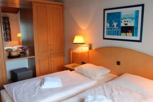 a hotel room with two beds and a picture on the wall at Landhaus Seeblick in Biersdorf