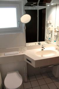a bathroom with a sink and a toilet and a mirror at Landhaus Seeblick in Biersdorf