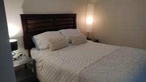 1 dormitorio con 1 cama con sábanas y almohadas blancas en HERMOSO APARTAMENTO CON TERRAZA Y VISTA AL MAR, en Viña del Mar
