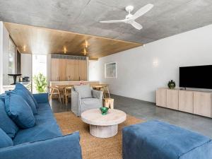 a living room with a blue couch and a table at Driftwood Three At Clarkes Beach in Byron Bay