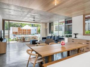 a kitchen and living room with a wooden table at Driftwood Three At Clarkes Beach in Byron Bay