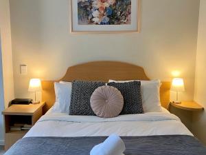 - une chambre avec un grand lit et deux lampes dans l'établissement 203 Cute As A Button Wkitchen For 2cbd, à Perth