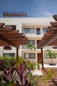 a building with a lot of plants in front of it at Apartment and Penthouse Blue Luxury Kukulkan Tulum in Tulum