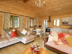 a living room with two couches and a kitchen at The Firs in Llanidloes