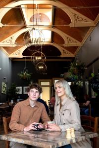mężczyzna i kobieta siedzący przy stole w restauracji w obiekcie Bull and Mouth Hotel w mieście Maryborough
