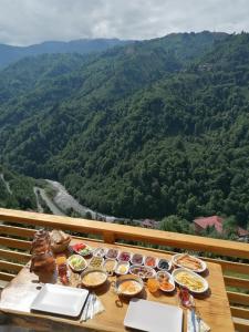 uma mesa com pratos de comida no topo de uma montanha em Vadi dağ evi bungalov em Çamlıhemşin