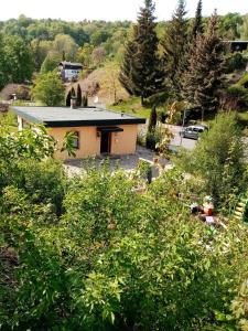 una casa en una colina con árboles en primer plano en Haus Affalterthal en Egloffstein