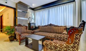 a living room with a couch and chairs and a table at Treebo Trend Siesta Muralinagar in Visakhapatnam