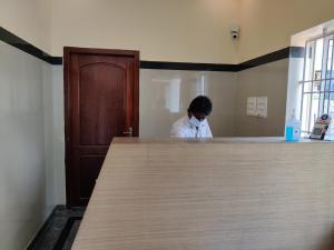a man wearing a face mask behind a counter at Hotel Wins in Kanyakumari