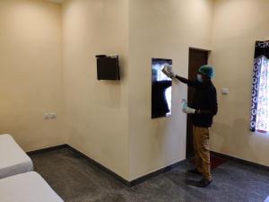 a man is painting a wall in a room at Hotel Wins in Kanyakumari