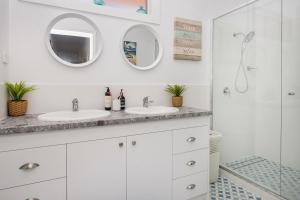 a white bathroom with two sinks and a shower at Green House in Busselton +18 photos