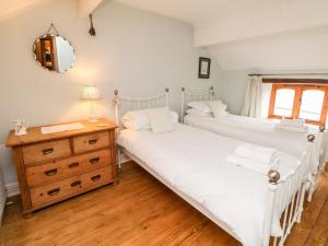 タイズウェルにあるKempshill Cottageのベッドルーム(ドレッサー、鏡付)のベッド2台