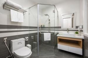 a bathroom with a shower and a toilet and a sink at Arrive Hotel & Apartment in Danang +44 photos