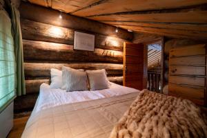 a bedroom with a bed in a wooden wall at Saaruantähti Cottage in Ruka