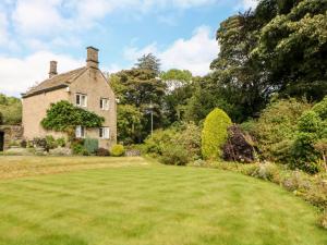 an old house with a large lawn in front of it at Underbank Hall Cottage in Stocksbridge