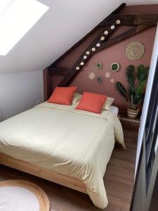 a bedroom with a large bed with red pillows at la cantina in Charleville-Mézières