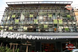 a building with a bunch of white chairs in front of it at My Friends Hotel in Trang