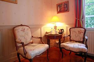 Habitación con 2 sillas y mesa con lámpara. en Les Chambres de Mathilde, en Angers