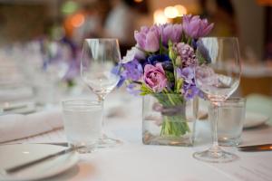 een tafel met wijnglazen en een vaas met bloemen bij Premier Resort Mpongo Private Game Reserve in Macleantown