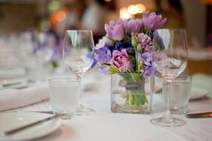 a table with wine glasses and a vase of flowers at Premier Resort Mpongo Private Game Reserve in Macleantown