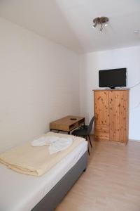a bedroom with a bed and a desk and a television at Neubert`s Gasthaus am Rhein in Lahnstein