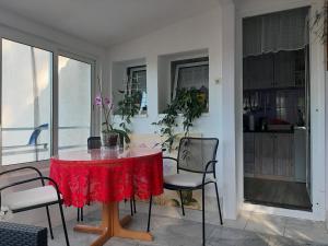 a dining room with a red table and chairs at The Look in Mali Lošinj