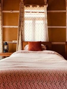 a bedroom with a bed with a window at PaliGhar Farmstay in Kalimpong